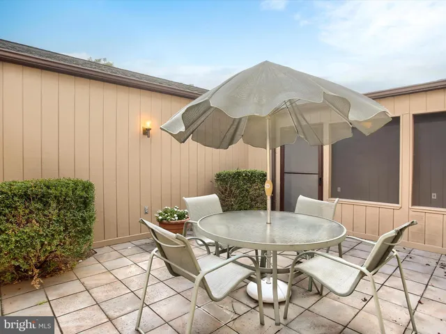 a outdoor dining space with furniture and a black umbrella