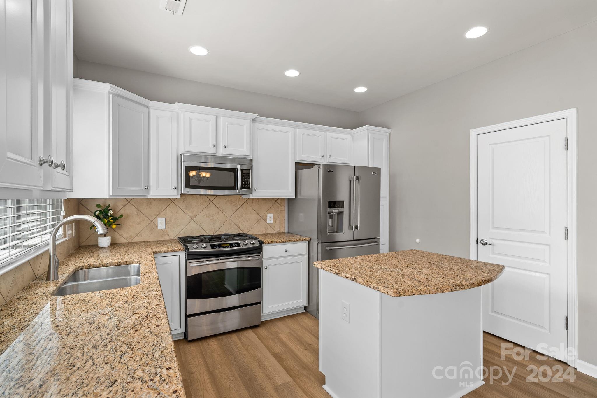 926 Lyndley Drive Fort Mill, SC 29708 - Photo 17 of 36 a kitchen with granite countertop a stove a sink and a refrigerator