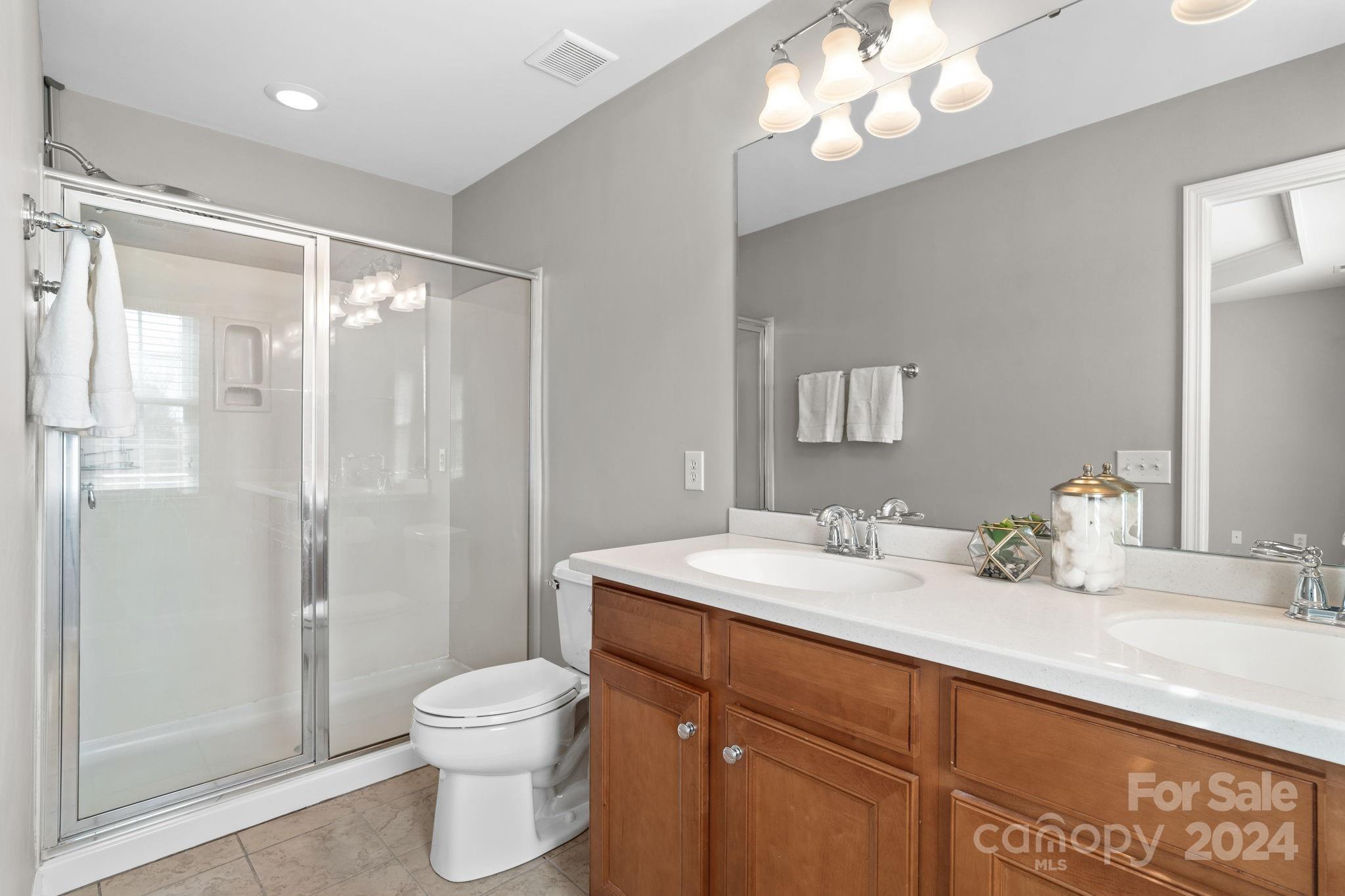 926 Lyndley Drive Fort Mill, SC 29708 - Photo 31 of 36 a bathroom with a toilet a sink a mirror a vanity and shower