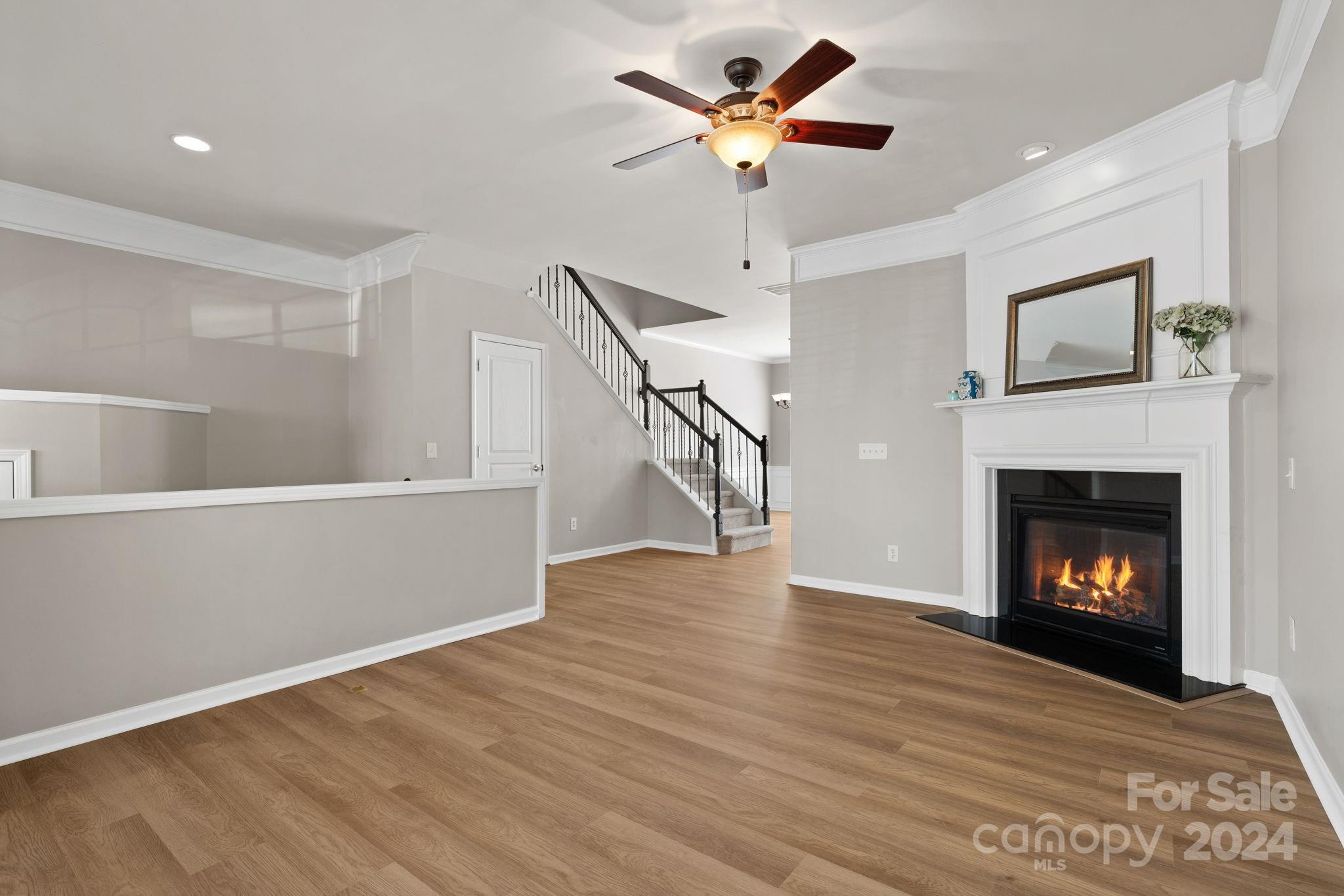 926 Lyndley Drive Fort Mill, SC 29708 - Photo 9 of 36 a view of an empty room with wooden floor a fireplace and a window