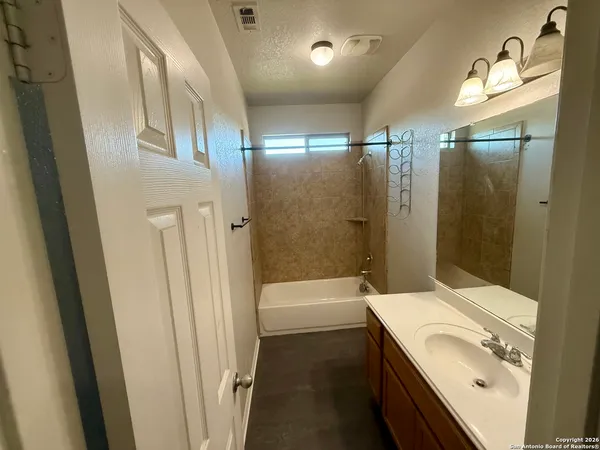 a bathroom with a sink a toilet a tub and shower