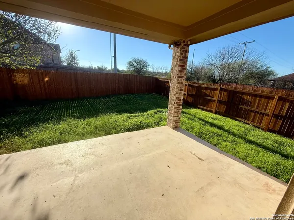 a view of a backyard with wooden fence