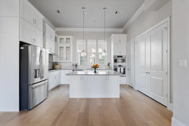 a kitchen with white cabinets and stainless steel appliances