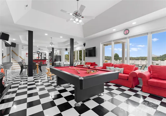 a living room with a black white checkered floor with couches chair and a coffee table