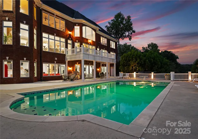 a view of a swimming pool with a lawn chairs under an umbrella