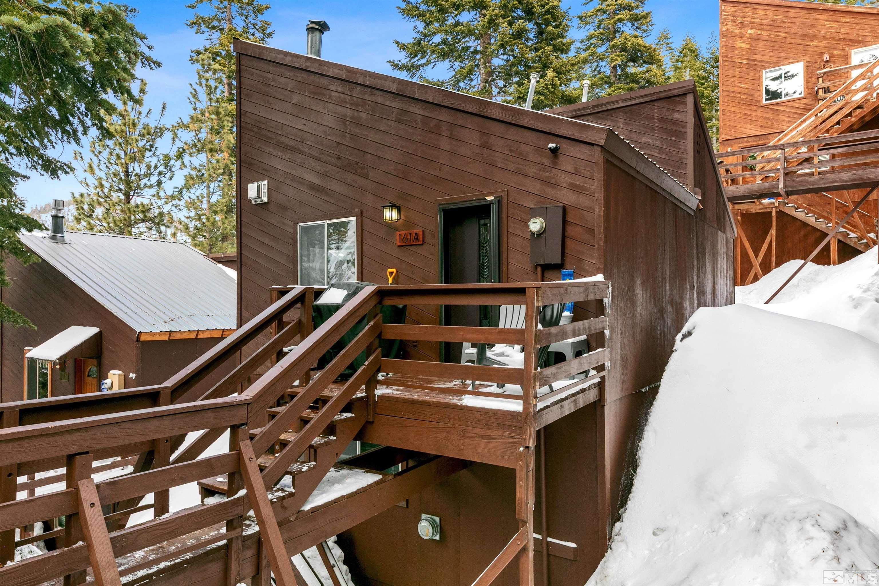 a view of a balcony with chairs and wooden fence