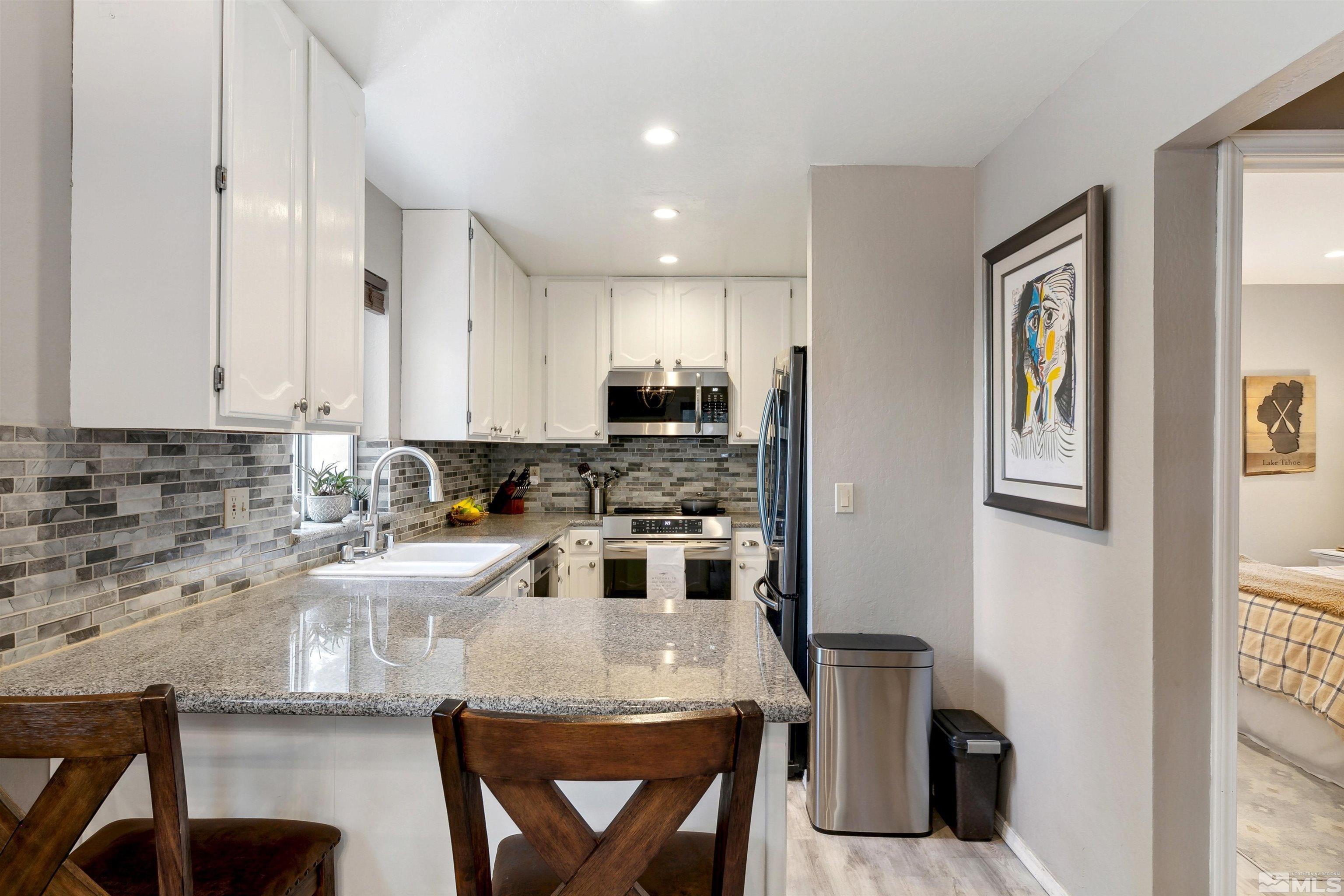 161 Tramway Drive, Unit A Stateline, NV 89449 - Photo 9 of 28 a kitchen with a stove a refrigerator and a sink