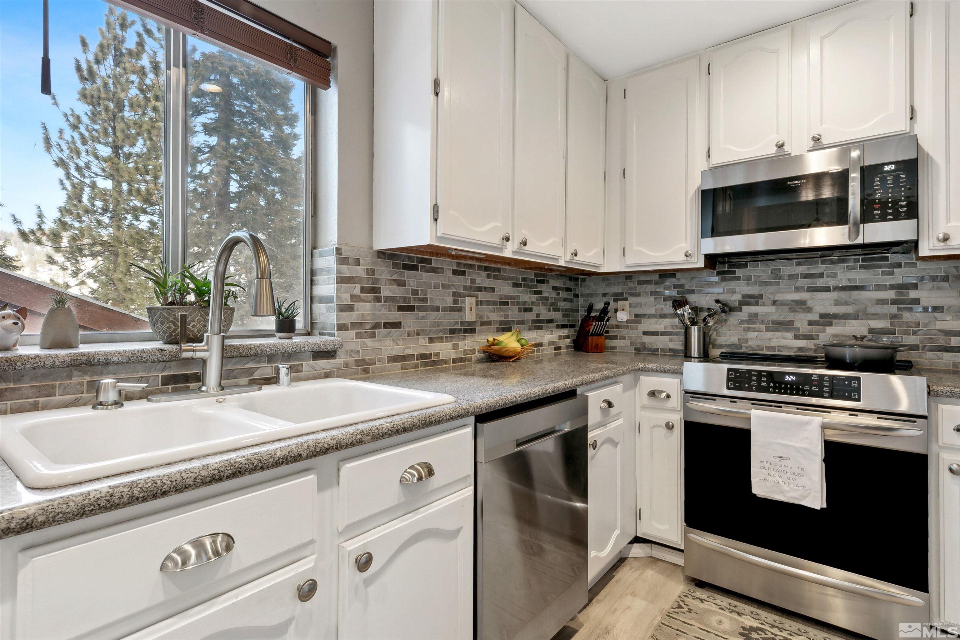 161 Tramway Drive, Unit A Stateline, NV 89449 - Photo 10 of 28 a kitchen with stainless steel appliances granite countertop a sink stove and microwave