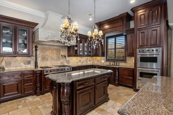 a kitchen with stainless steel appliances granite countertop a stove a sink and a microwave