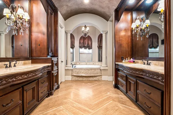 a spacious bathroom with a granite countertop tub a double vanity sink and a mirror