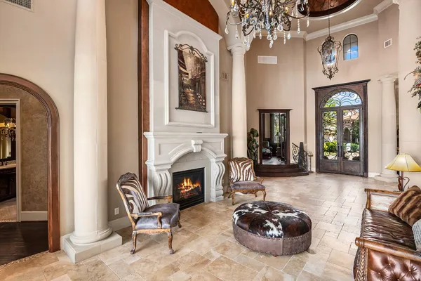 a living room with furniture a chandelier and a fireplace