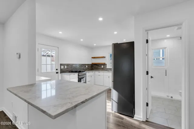 a kitchen with stainless steel appliances granite countertop a refrigerator a sink and a stove