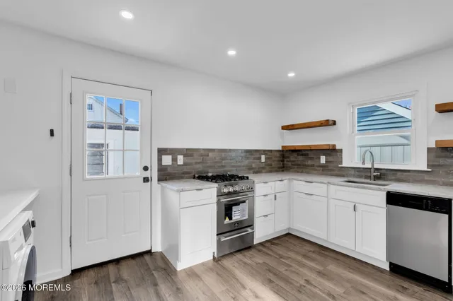 a kitchen with granite countertop white cabinets and white appliances