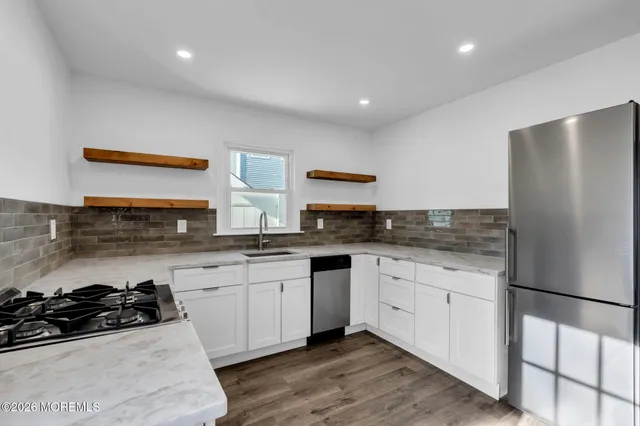 a kitchen with stainless steel appliances granite countertop a sink stove and refrigerator