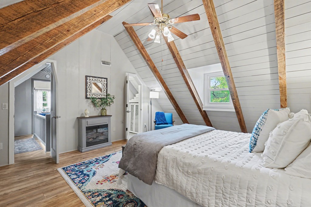 4609 Matheson Road Hiawassee, GA 30546 - Photo 39 of 57 a bedroom with a bed flat screen tv and a fireplace