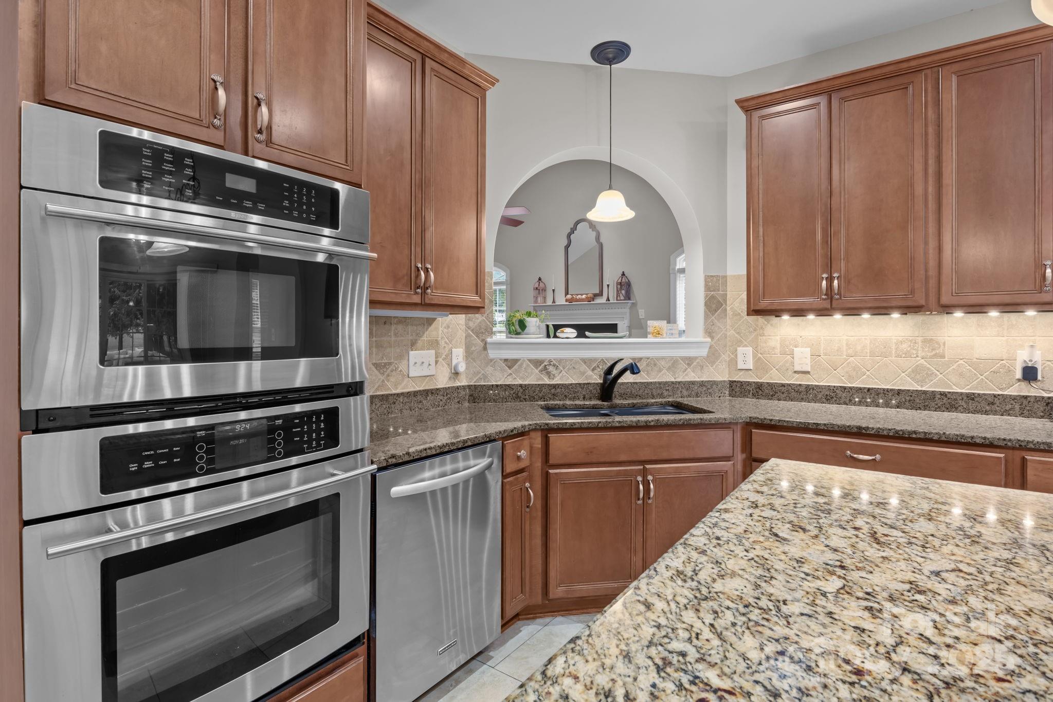802 Seipel Drive Denver, NC 28037 - Photo 24 of 35 a kitchen with stainless steel appliances kitchen island granite countertop a stove microwave and sink
