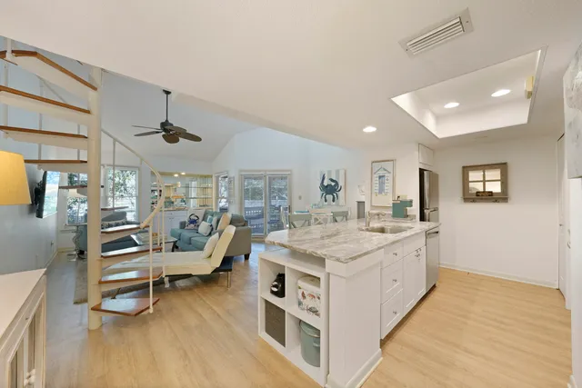 a large white kitchen with a large window and stainless steel appliances