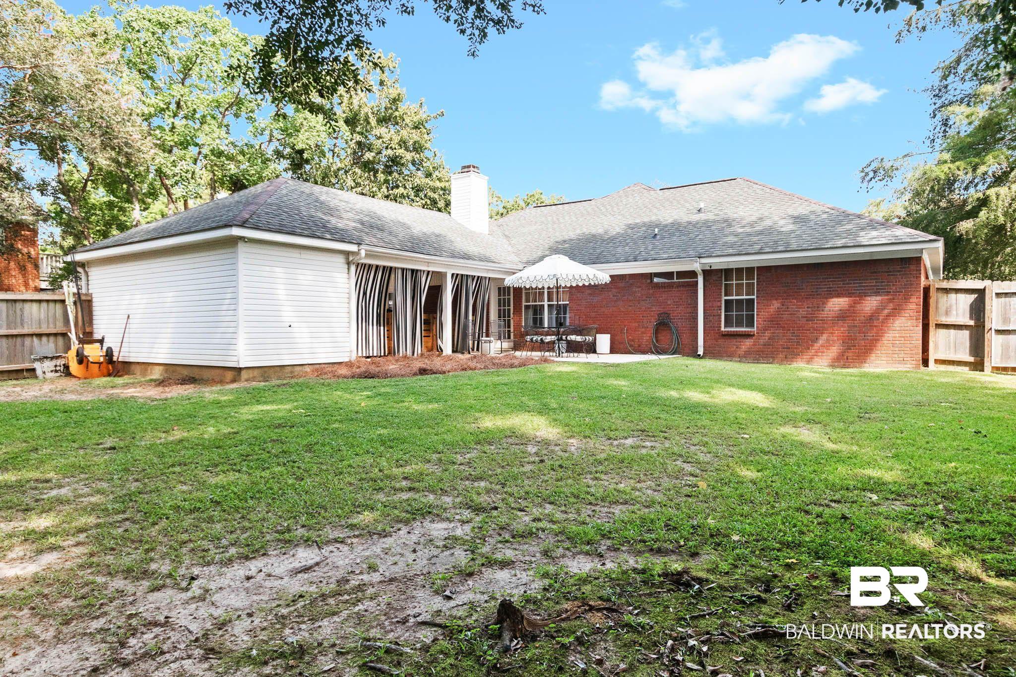 20685 Lowry Drive Fairhope, AL 36532 - Photo 48 of 48 Back of property with a patio area, a shingled roof, a chimney, and brick siding