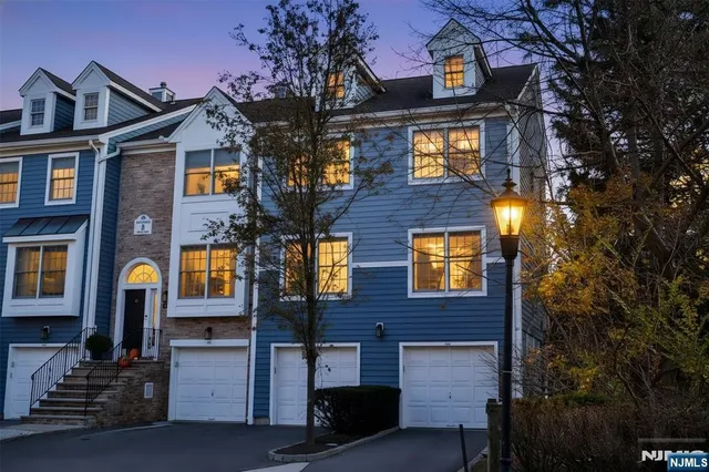 a front view of a building with glass windows and a tree