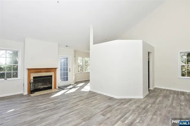 a view of a livingroom with wooden floor and a fireplace