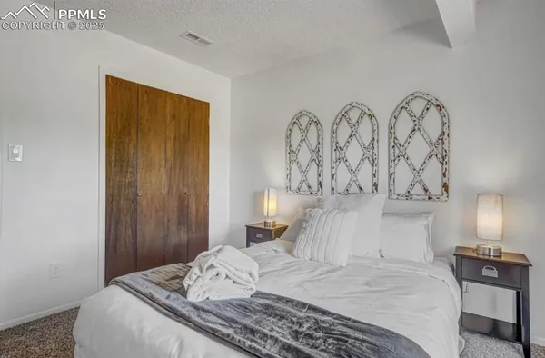 a bedroom with a bed and painting on the wall