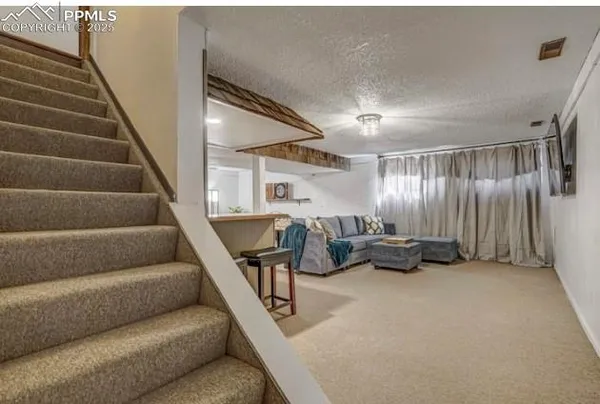 a living room with furniture and kitchen view