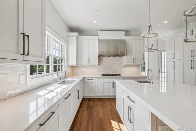 a kitchen with stainless steel appliances granite countertop a sink a stove and a refrigerator