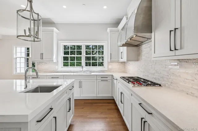 a kitchen with stainless steel appliances a sink a stove and cabinets