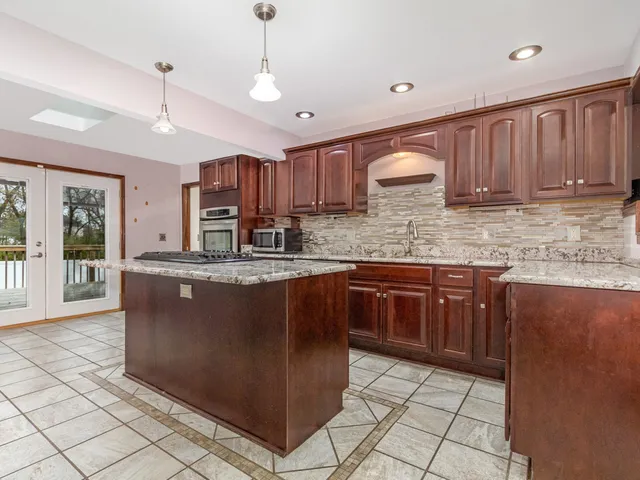 a kitchen with kitchen island granite countertop a cabinets a counter top space and appliances