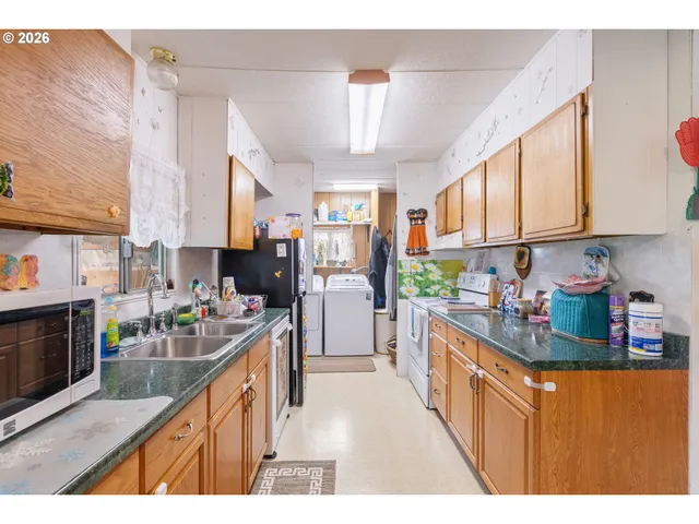 a kitchen with stainless steel appliances granite countertop a stove a sink dishwasher and cabinets with wooden floor