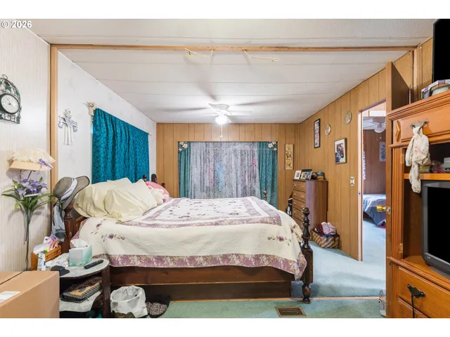 a bed room with a bed tv and a window