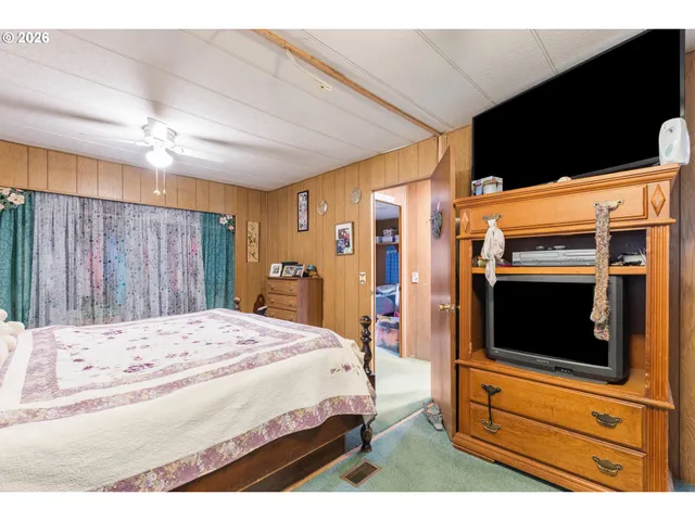 a bedroom with a bed and a flat screen tv