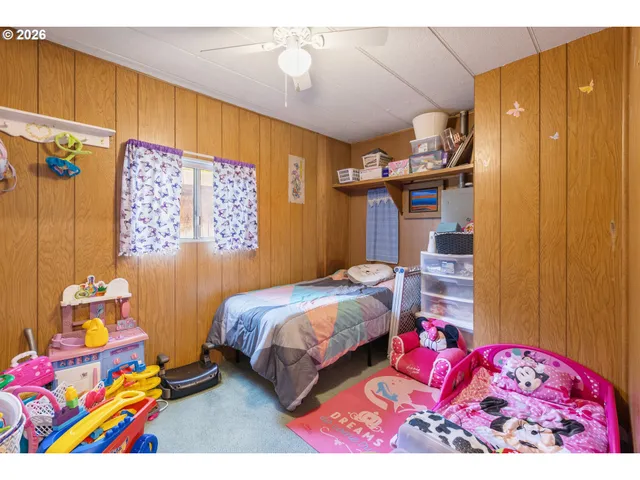 a bedroom with a bed dresser and a window