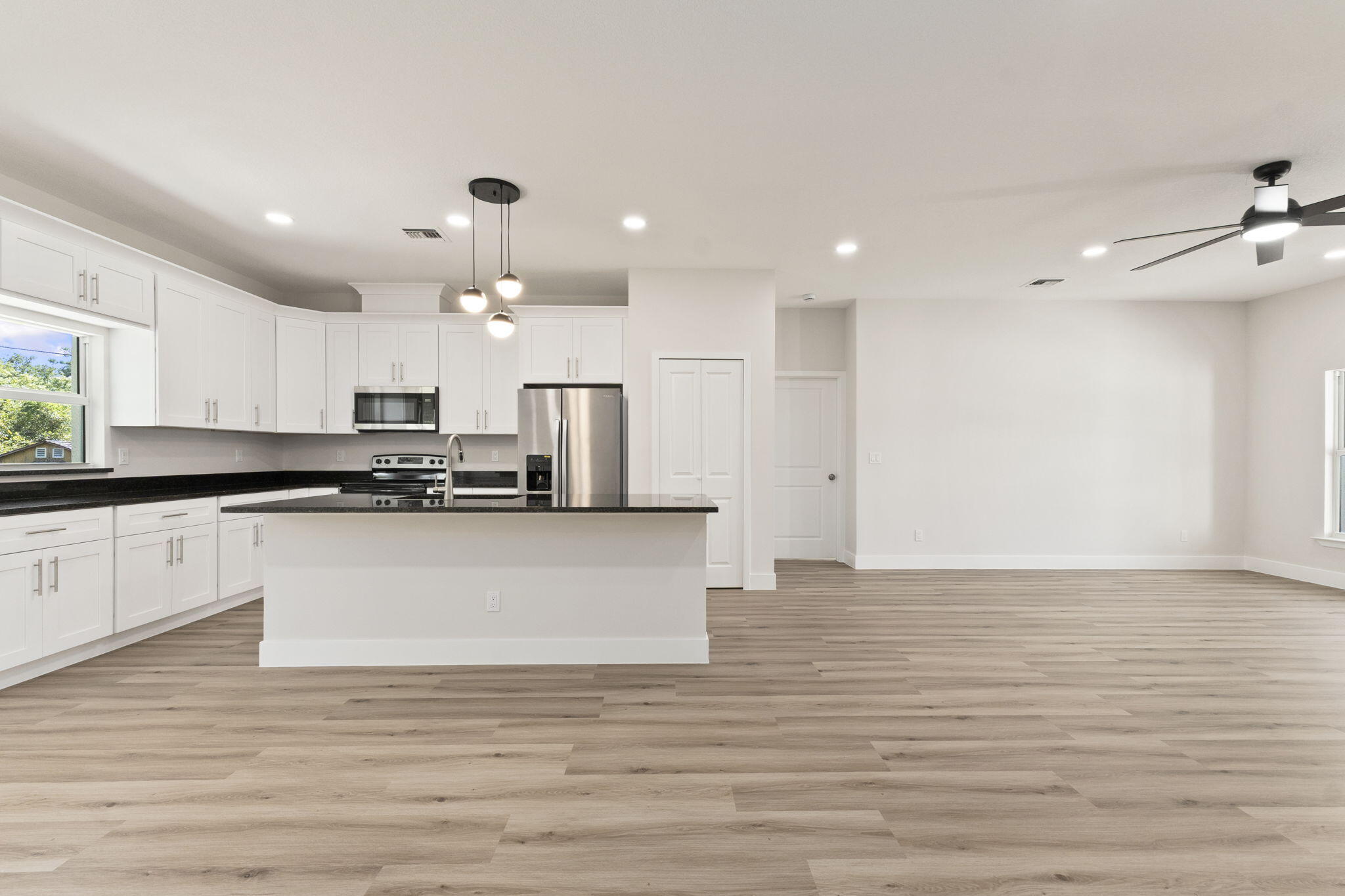 5310 Sunset Boulevard Fort Pierce, FL 34982 - Photo 16 of 39 a large white kitchen with kitchen island a sink stainless steel appliances and cabinets
