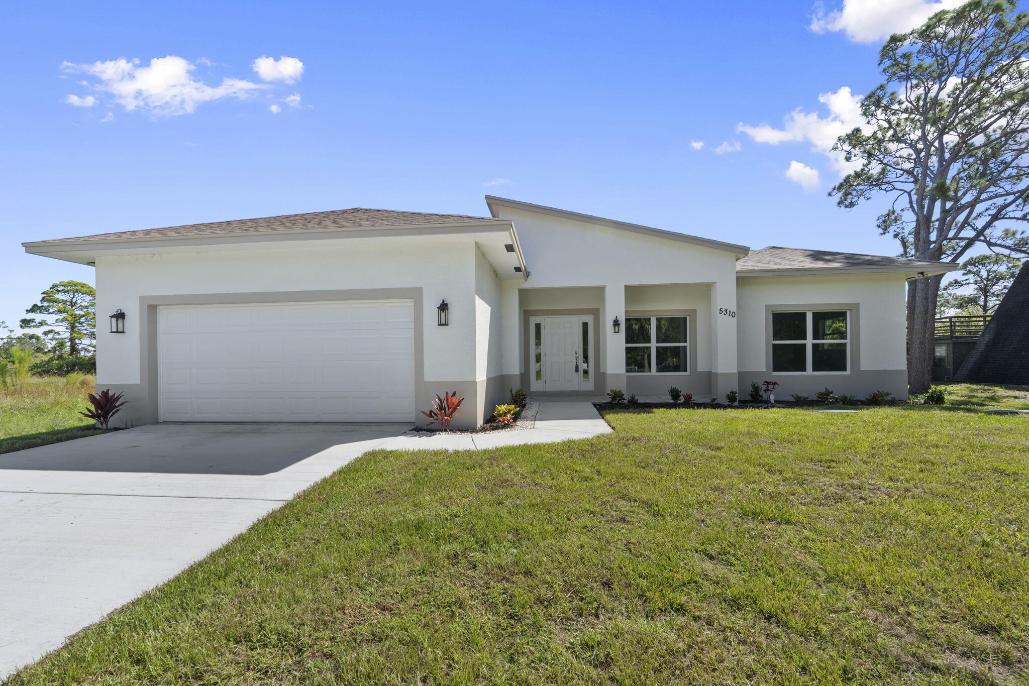 5310 Sunset Boulevard Fort Pierce, FL 34982 - Photo 8 of 39 a front view of a house with a yard and garage