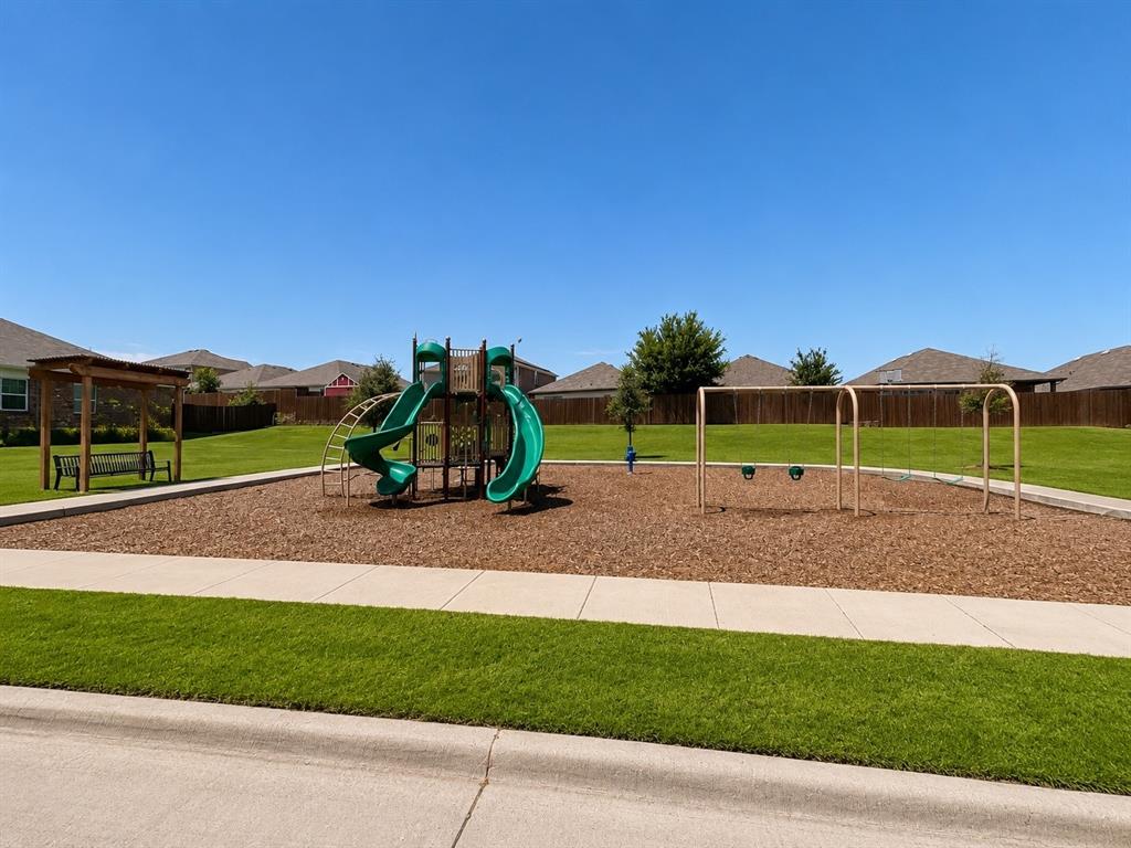 824 Juniper Street Anna, TX 75409 - Photo 24 of 25 Community green space featuring a playground with slides and swings
