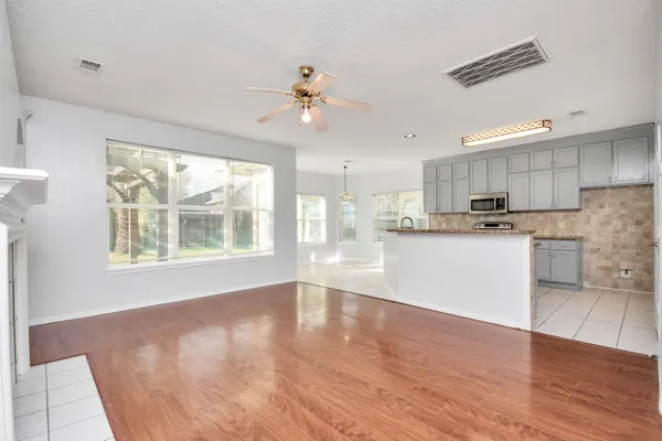 a view of an empty room with kitchen view and a window