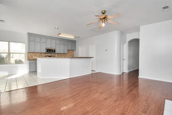 a view of a kitchen with a sink a refrigerator and wooden floor