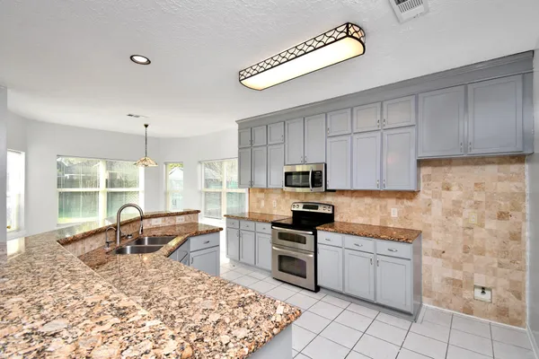 a kitchen with stainless steel appliances granite countertop a stove sink and cabinets