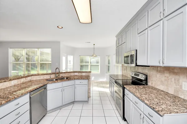 a kitchen with stainless steel appliances granite countertop a stove a sink and a microwave
