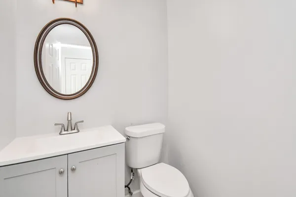 a bathroom with a toilet a sink and a mirror