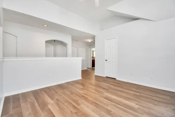 a view of an empty room with wooden floor