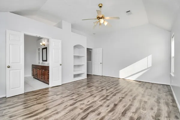 wooden floor in an empty room with a chandelier