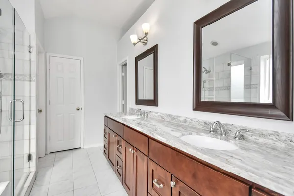 a bathroom with double sink and a mirror