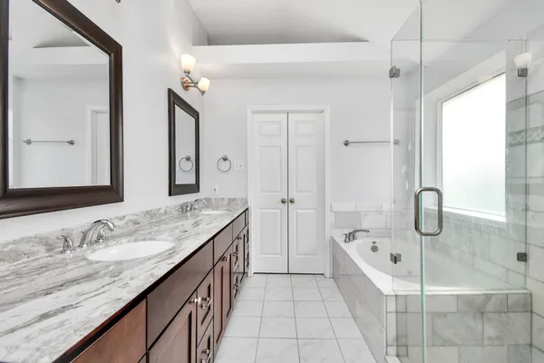 a bathroom with a granite countertop sink mirror and bathtub