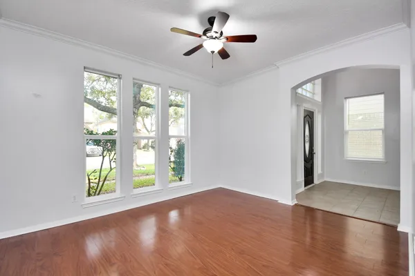 a view of an empty room with window and wooden floor