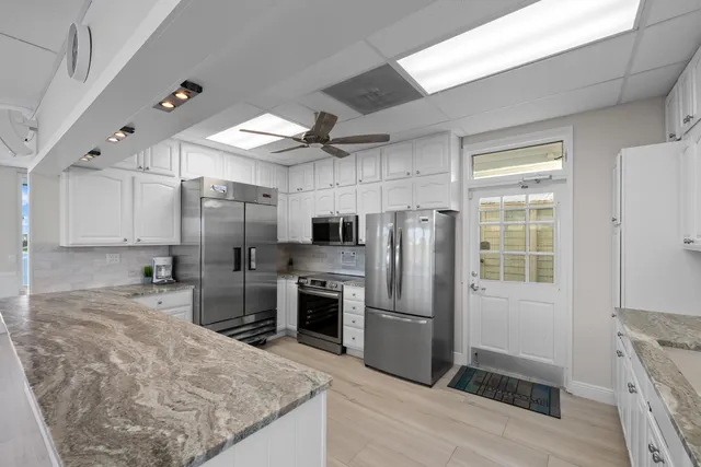 a kitchen with stainless steel appliances a sink a stove a refrigerator and cabinets