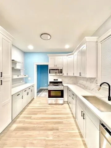 a large kitchen with granite countertop a stove and a sink