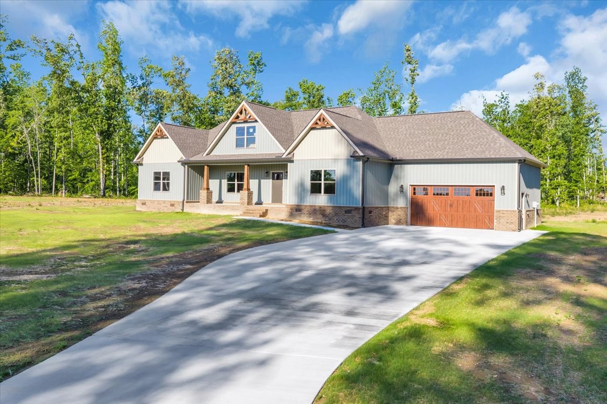 a front view of a house with a yard and trees