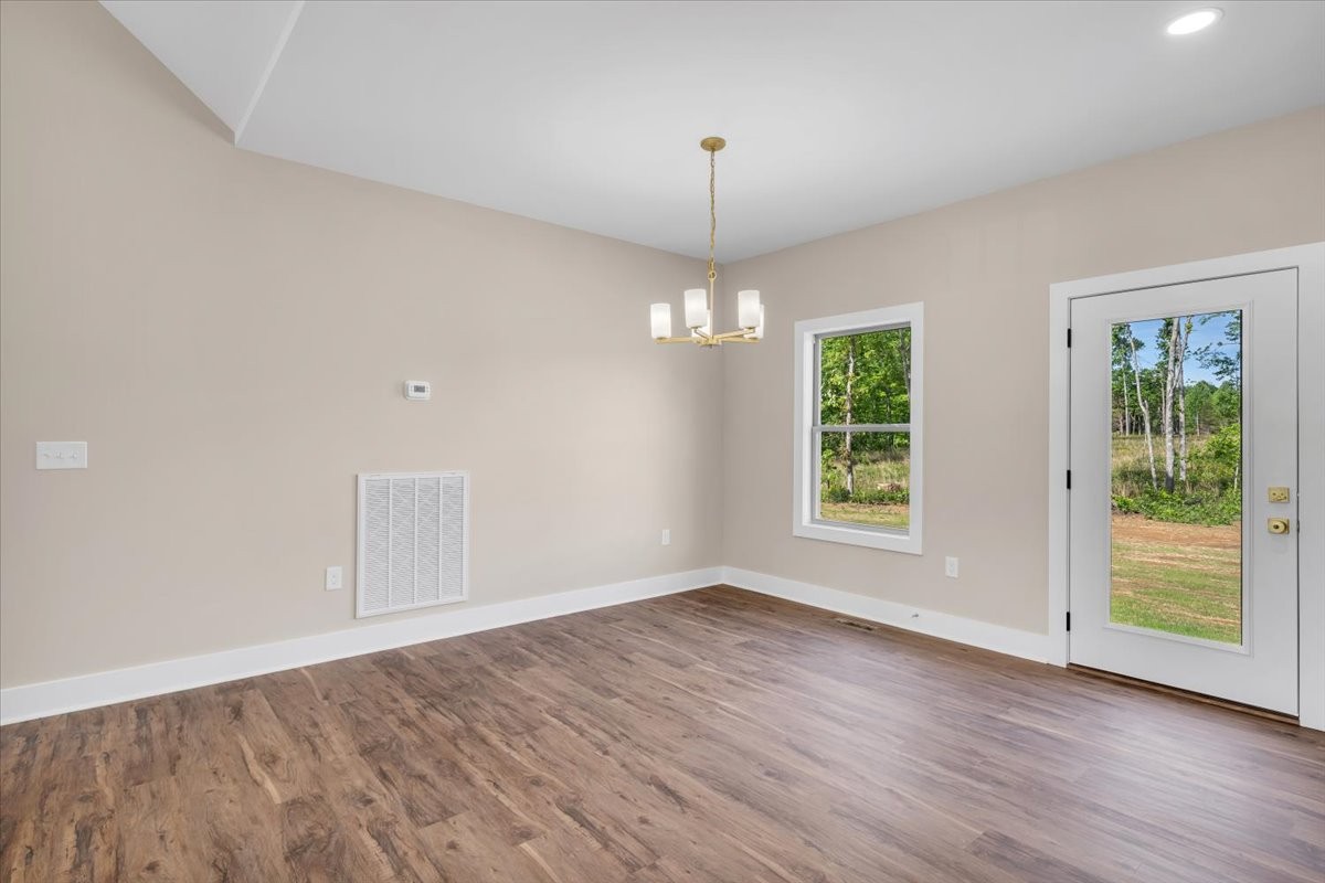 139 Brinkley Road Wartrace, TN 37183 - Photo 7 of 41 an empty room with wooden floor chandelier and windows